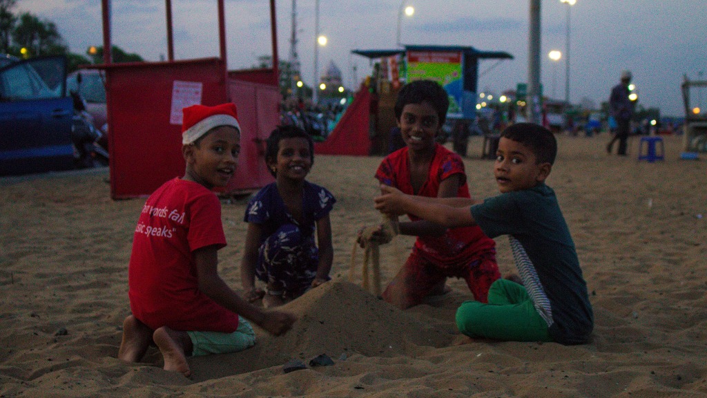 Kids playing in the beach sand at evening