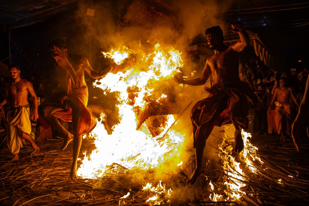 Theyyam dancer leaping over hot embers